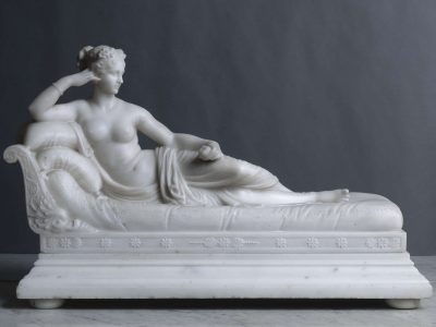 a statuette of a woman resting on a bed