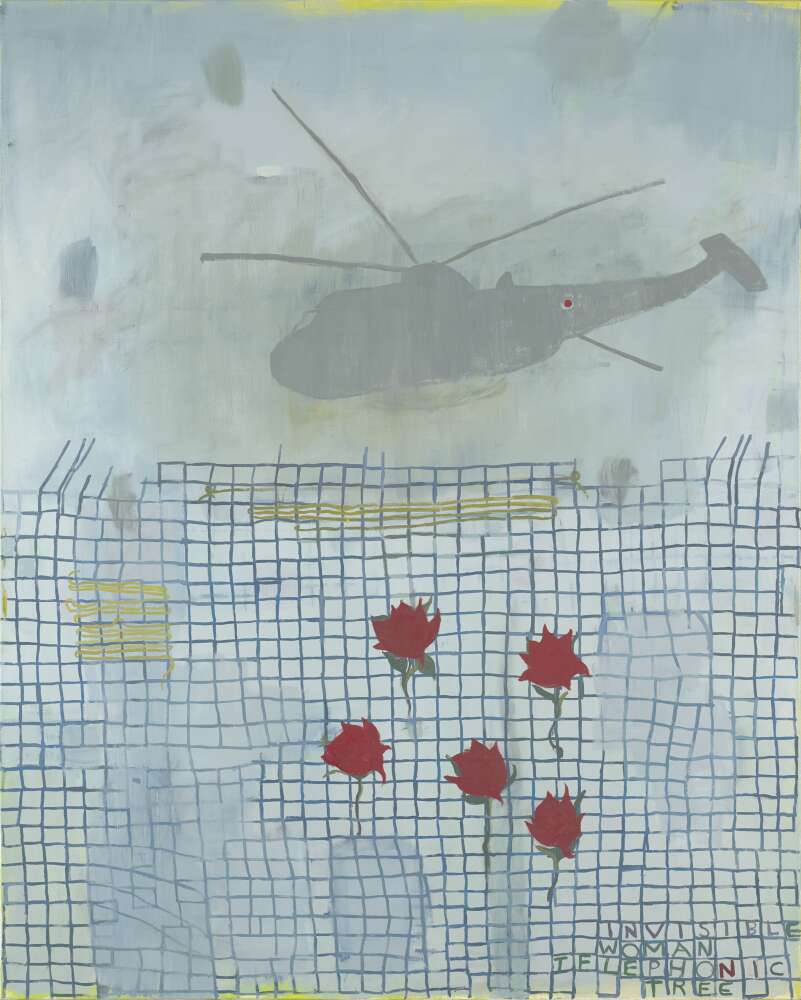 Five red roses are placed on a rickety patched up wire fence. A helicopter looms in the distance.